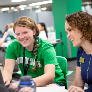 Advisor assisting student on computer